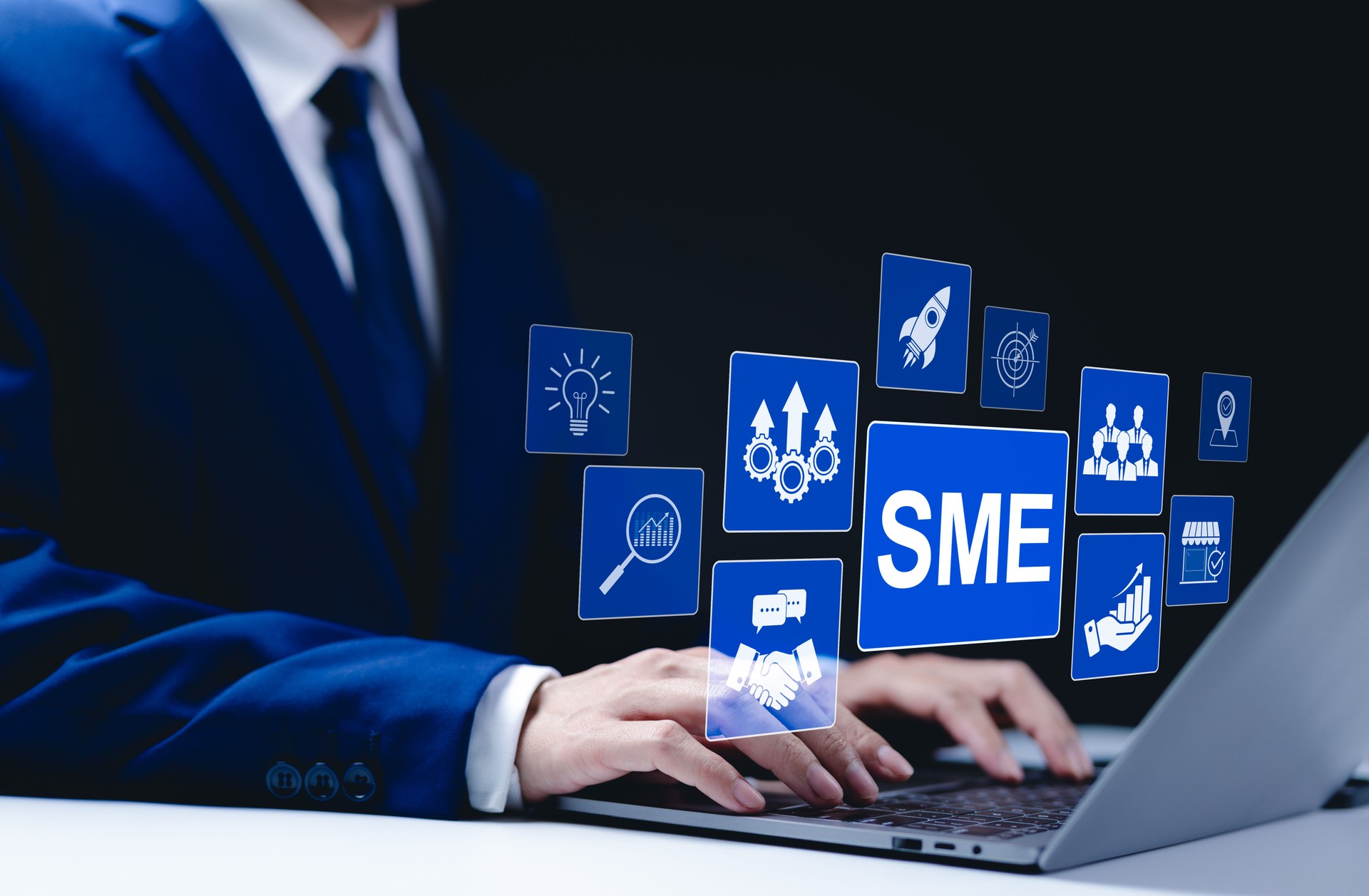 SME Business Growth and Success Concept. Businessman typing on a laptop with digital icons representing small and medium-sized enterprises, innovation, and growth strategies. SMEs, Startup company,